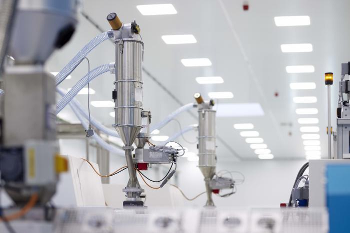Production facility for pharmaceutical packaging with automated manufacturing equipment